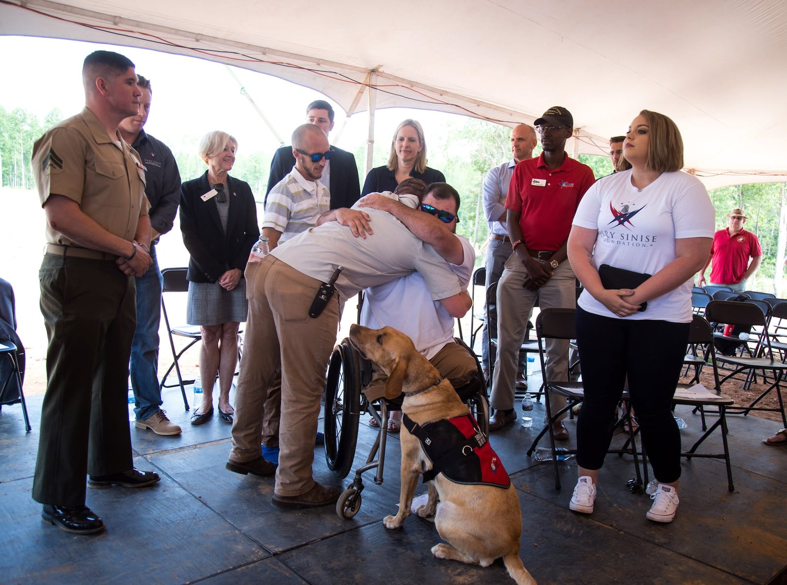 Lance Cpl. Mark Rhyne hugs Sean Adams during the dedication of Adams’ new home in Maysville on May 19, 2017. Rhyne was one of the Marines who dragged Adams from the battlefield in Afghanistan on Feb. 10, 2012, when Adams was nearly killed. STEVE SCHAEFER / SPECIAL TO THE AJC