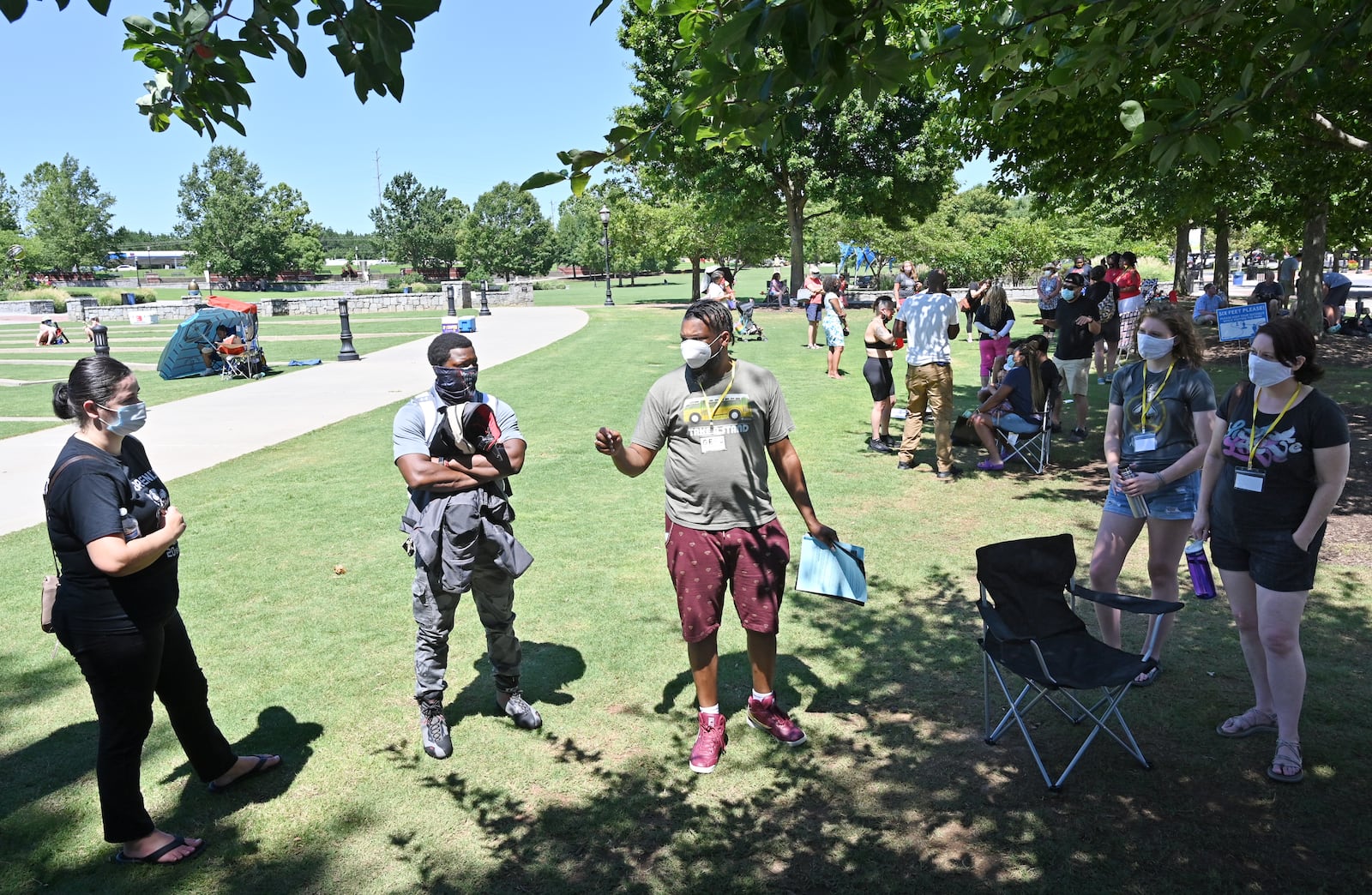 July 11, 2020 Suwanee - Demetrius Nelson (center), 7th grade math teacher at Summerour middle school leads a small group discussion during Gwinnett Citizens for Equity and Justice event, a rally and information session organized by Gwinnett Educators for Equity & Justice, at Town Center Park in Suwanee on Saturday, July 11, 2020. They are explaining their stance on forcing Gwinnett schools to include implicit bias training for educators, include cultural and racial history and education in curriculum and hire more teachers of color.  (Hyosub Shin / Hyosub.Shin@ajc.com)