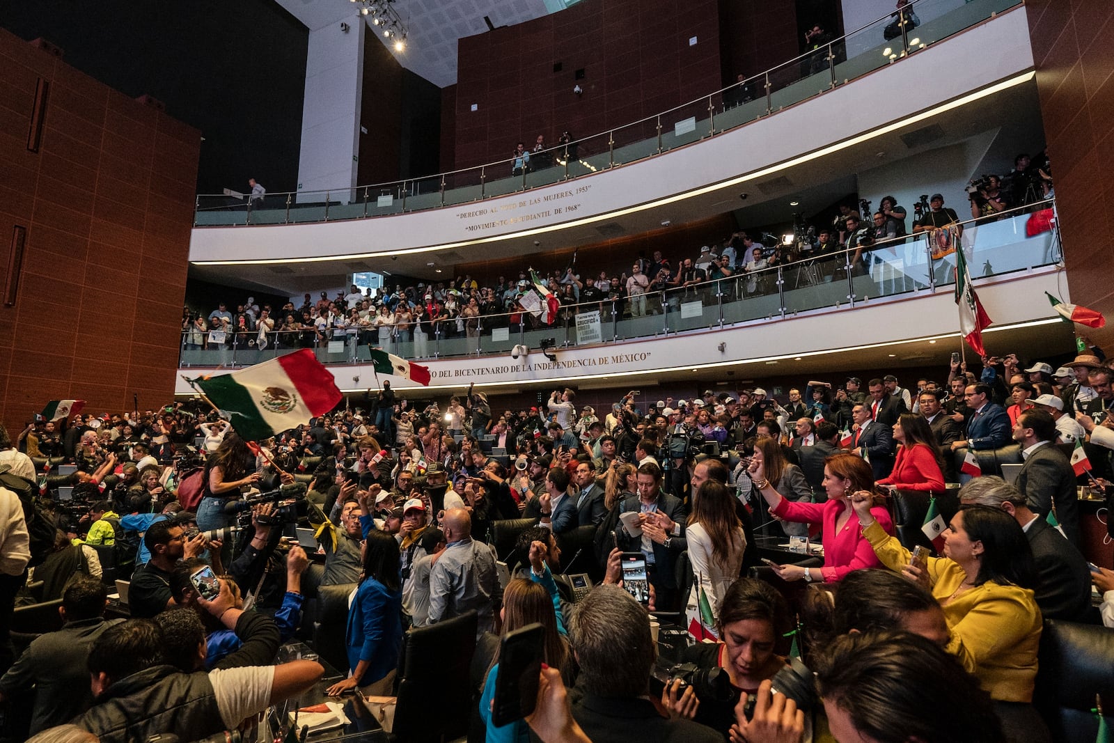 Protesters stand alongside opposition Senators after interrupting a debate over the government's proposed judicial reform, which would make judges stand for election, in Mexico City, Tuesday, Sept. 10, 2024. (AP Photo/Felix Marquez)