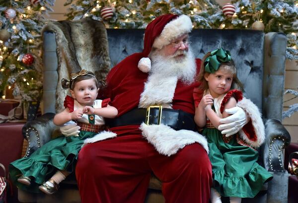 Saylor Willis, 2, seems at ease, but Sotton Willis, 3, looks like she has reservations about this photo session with Santa. The Willis girls were among the customers at Jeff Roffman’s photo studio on a recent November afternoon. Roffman has become well-known for his artful (and sometimes tearful) images of children with Santa. HYOSUB SHIN / HSHIN@AJC.COM