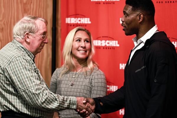 Floyd Farless (left) shakes hands with Republican U.S. Senate candidate Herschel Walker as U.S. Rep. Marjorie Taylor Greene  looks on. Greene referred to the 2020 election in urging Republicans to turnout for this year's contest on Nov. 8. “Do we sit on the sidelines because we might be a little bit disappointed about the way things went last time? No," she said. "You don’t sit out the fight. You get out there and you vote.” (Natrice Miller/natrice.miller@ajc.com)  