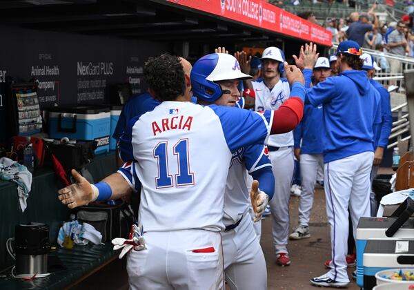 Orlando Arcia (left) celebrates with Jarred Kelenic in the dugout on June 15, 2024 in Atlanta. (Hyosub Shin / AJC)