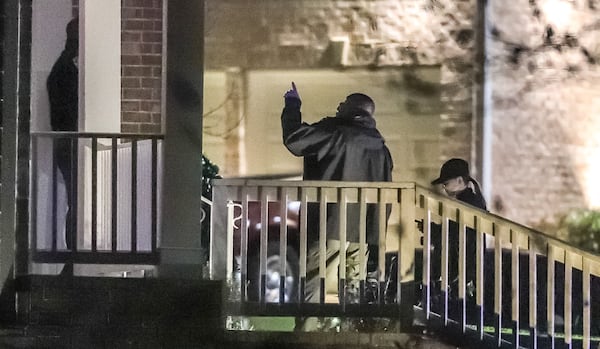 Investigators collect evidence at a home on Grammercy Drive in South Fulton where a woman was shot and a man was taken into custody after a SWAT standoff Thursday.