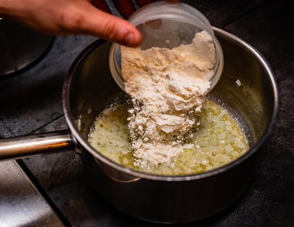 Chef Jeb Aldrich of Tiny Lou’s adds flour to butter to begin making a roux, on the way to creating bechamel sauce. CONTRIBUTED BY HENRI HOLLIS