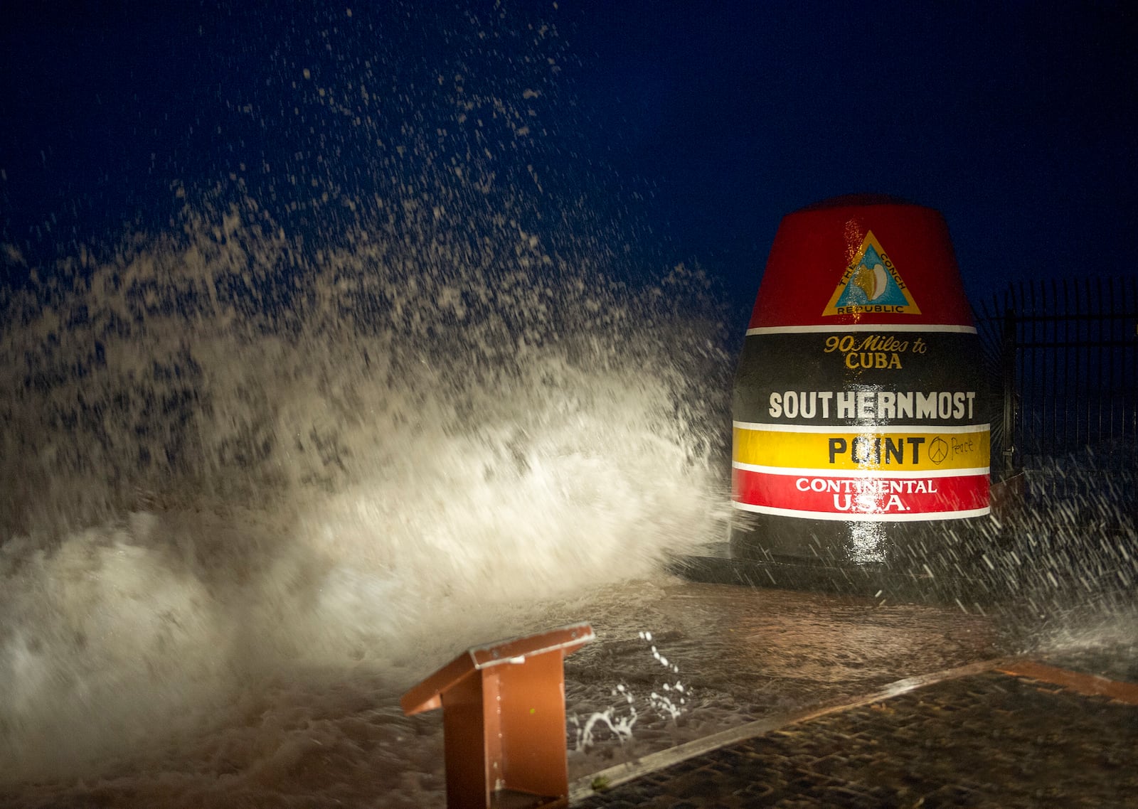 Waves crash against the Southernmost Point in Key West, Fla., Saturday, Sept. 9, 2017. Hurricane Irma's leading edge bent palm trees and spit rain as the storm swirled toward Florida on Saturday. (Rob O'Neal/The Key West Citizen via AP)