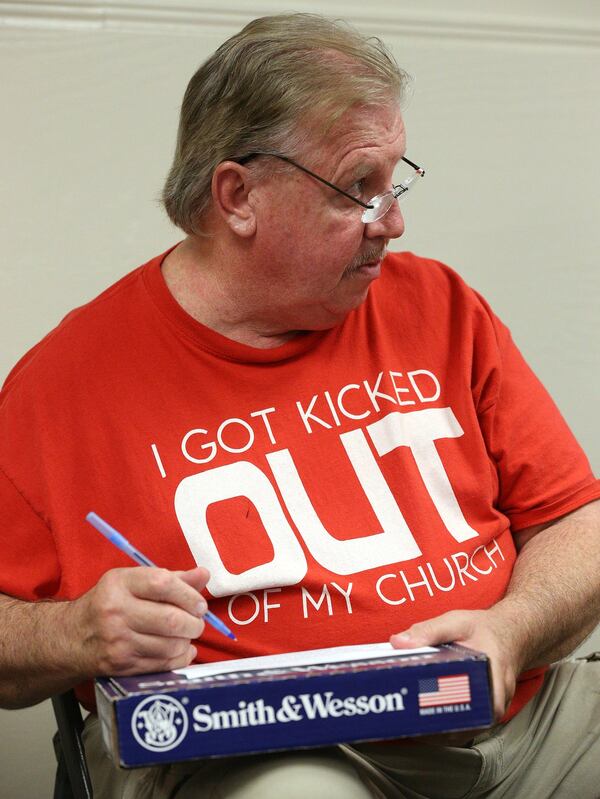 Jim Cronin takes notes on top of his firearm box while attending the Community Bible Church monthly men’s study group at the American Heritage Gun Range. This Bible and bullets approach to the Gospel is attracting a growing number of men, including Cronin, who has attended since the inception. CURTIS COMPTON / CCOMPTON@AJC.COM