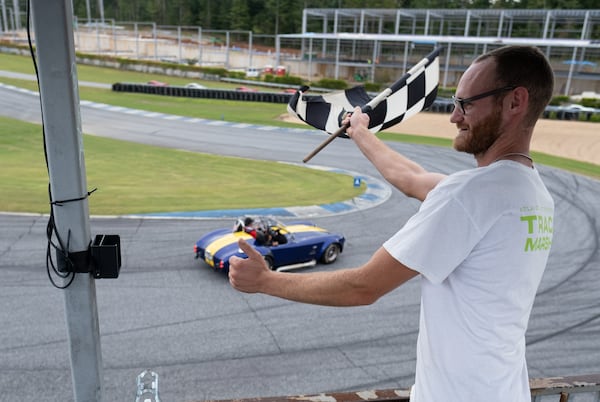 Brent Landry waves the checkered flag as cars circle Atlanta Motorsports Park in Dawsonville  during Ferrari of Atlanta’s annual Rides to Remember 2021 event Saturday morning, Sept. 18, 2021. (Photo: Ben Gray for The Atlanta Journal-Constitution)