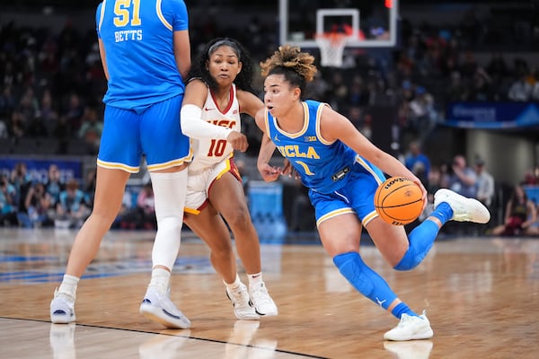 UCLA guard Kiki Rice (1) drives the ball as Southern California guard Malia Samuels (10) works around a screen by Lauren Betts (51) during the second half of an NCAA college basketball game in the championship of the Big Ten Conference tournament in Indianapolis, Sunday, March 9, 2025. (AP Photo/Michael Conroy)