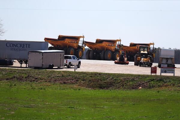 Heavy-duty grading equipment is parked at a construction entrance beside Davis Academy Road on the site of Rivian’s Georgia plant on Sunday, March 10, 2024, in Rutledge.  Curtis Compton for the Atlanta Journal Constitution