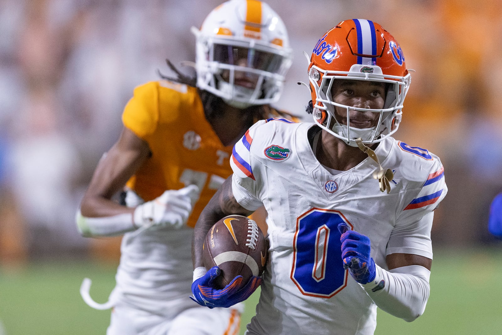 Florida defensive back Sharif Denson (0) returns an interception as he's chased by Tennessee wide receiver Chris Brazzell II (17) during the first half of an NCAA college football game Saturday, Oct. 12, 2024, in Knoxville, Tenn. (AP Photo/Wade Payne)