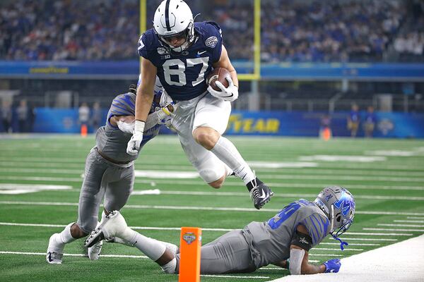 Penn State tight end Pat Freiermuth (87) leaps past Memphis defensive backs Chris Claybrooks (7) and Carlito Gonzalez (29) in an attempt to reach the end zone during the Cotton Bowl on Saturday, Dec. 28, 2019, in Arlington, Texas. Freiermuth was ruled out of bounds inside the 5-yard line. (Ron Jenkins/AP)