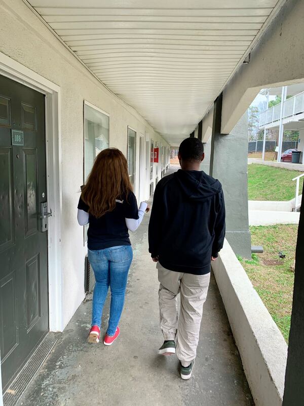 Chara McGill, left, with the nonprofit Housing Plus, talks recently with a man living at the Economy Hotel in Forest Park about finding a permanent home. CONTRIBUTED