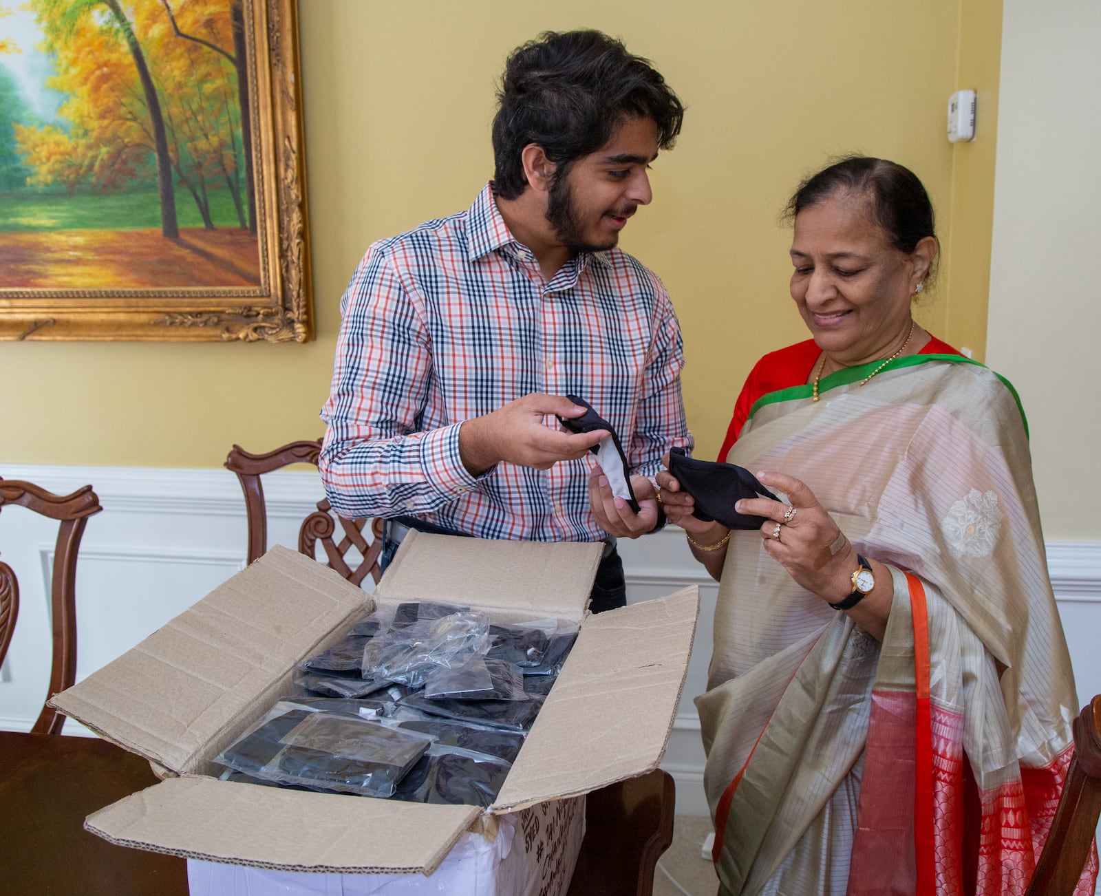 Westminster School senior Azeez Ishaqui (left) and his grandmother Najma look through a box of face masks that just arrived in their Smyrna home. During the pandemic Azeez came up with an idea to have women from India sew face masks that he would donate to homeless shelters in metro Atlanta. His Grandmother helped him accomplish that with her connections there. He was a high school freshman when he started helping the poor in India, first providing carts for men selling goods, and then later providing sewing machines for widows so they could earn a living. His parents are both from India, and he has always been encouraged to help the poor there.  PHIL SKINNER FOR THE ATLANTA JOURNAL-CONSTITUTION.