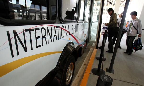 Passengers load onto a shuttle bus on their way to the domestic terminal at the Maynard H. Jackson Jr. International Terminal at Hartsfield-Jackson International Airport in Atlanta on May 24, 2012. (Jason Getz/Jason.Getz@ajc.com)