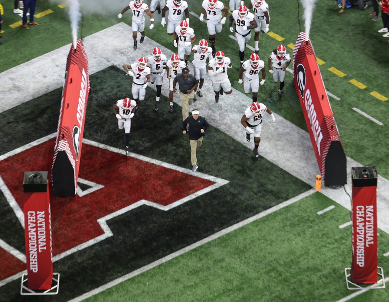 Georgia Bulldogs head coach Kirby Smart leads Georgia as they take the field at the 2022 College Football Playoff National Championship  between the Georgia Bulldogs and the Alabama Crimson Tide at Lucas Oil Stadium in Indianapolis on Monday, January 10, 2022.   Bob Andres / robert.andres@ajc.com