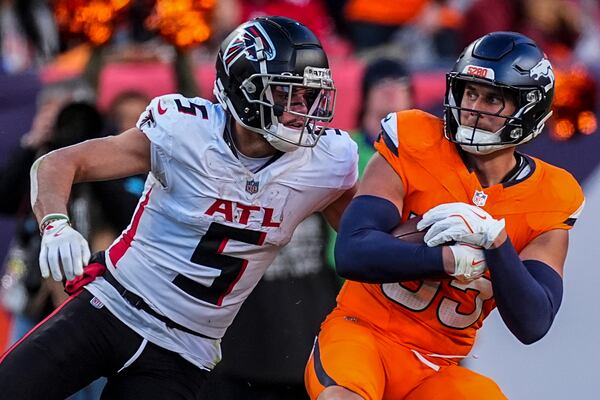 Atlanta Falcons wide receiver Drake London (5) hits Denver Broncos linebacker Cody Barton (55) after Barton's interception during the second half of an NFL football game, Sunday, Nov. 17, 2024, in Denver. (AP Photo/David Zalubowski)