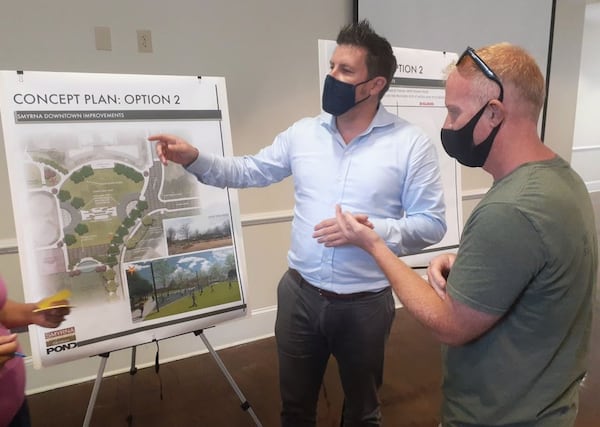 Pond & Company architect Andrew Kohr shows Smyrna resident John Dollarhide, right, a blueprint of one of the two proposed designs for Smyrna's $6.5 million downtown redevelopment during an open house Thursday night. (Matt Bruce/For the AJC)