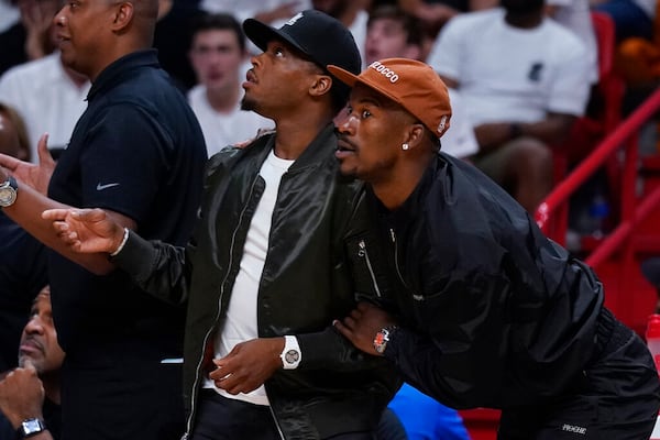 Miami Heat guard Kyle Lowry, left, and forward Jimmy Butler look on from the bench during the second half of Game 5 of an NBA basketball first-round playoff series against the Atlanta Hawks, Tuesday, April 26, 2022, in Miami. (AP Photo/Wilfredo Lee)