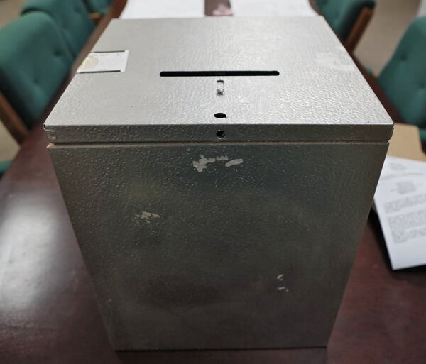 On election night for municipal contests in Chattahoochee Hills, poll workers tally the votes by opening a metal ballot box and calling out the names on each paper ballot. Residents watch and keep track of the counts on their own. Bob Andres / robert.andres@ajc.com