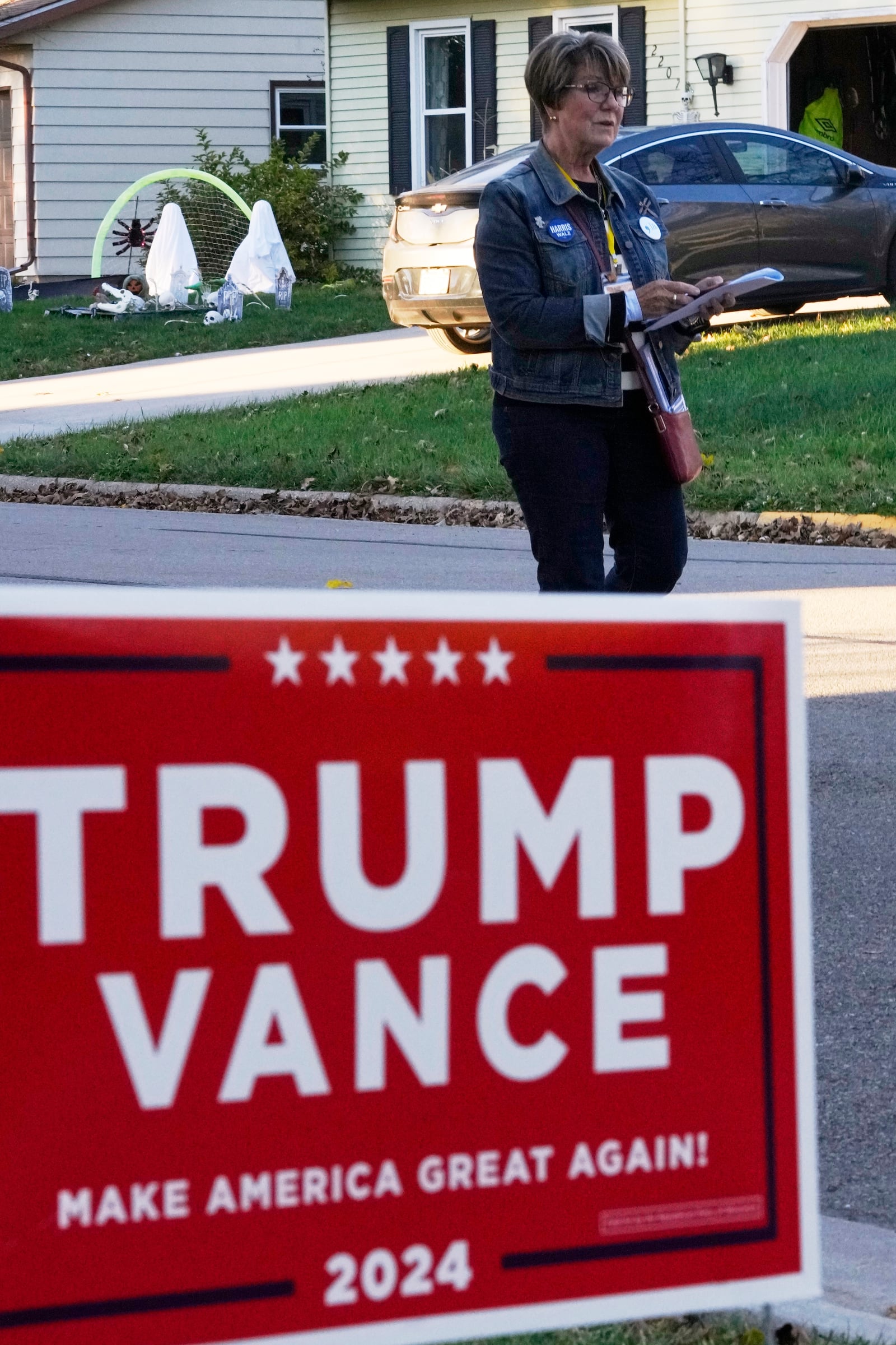 Kathy Moran canvases houses Wednesday, Oct. 23, 2024, in Cross Plains, Wis. (AP Photo/Morry Gash)