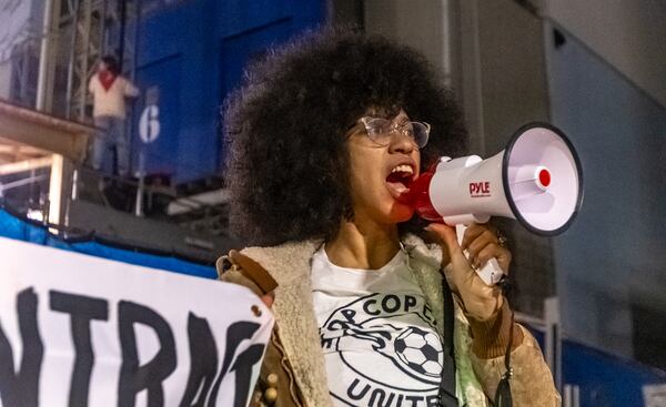 Mariah Parker with The People's Stop Work Order uses a bullhorn to lead chants as law enforcement try to extricate a protester from a construction elevator in Atlanta.

