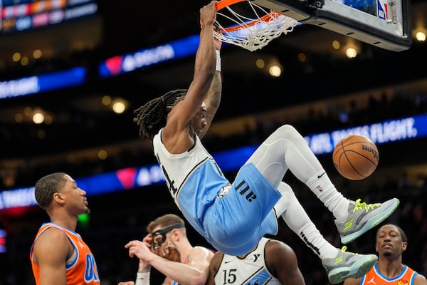 Atlanta Hawks guard Terance Mann (14) dunks against the Oklahoma City Thunder during the first half of an NBA basketball game, Friday, Feb. 28, 2025, in Atlanta. (AP Photo/Mike Stewart)