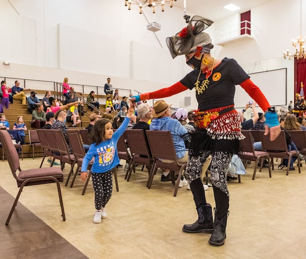 Crúz DiMuzio, 3, danced with Angela Carrington, a dancer with The Seed and Feed Marching Abominable Band during their performance at the 44th annual Groundhog Day Jugglers Festival in 2022 at the Yaarab Shrine Center. Carrington, died unexpectedly earlier this month.  (Jenni Girtman for The Atlanta Journal-Constitution)