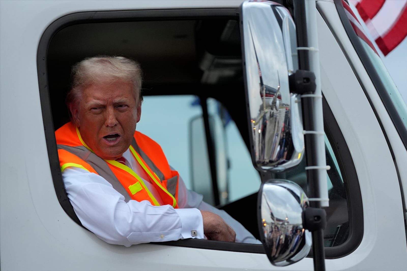 Former President Donald Trump talked to reporters as he sat in a garbage truck on Wednesday in Green Bay, Wis.