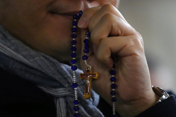 A man attends a rosary prayer with Cardinal Luis Antonio Tagle held for the health of Pope Francis in St Peter's Square at The Vatican, Tuesday, Feb. 25, 2025. (AP Photo/Kirsty Wigglesworth)