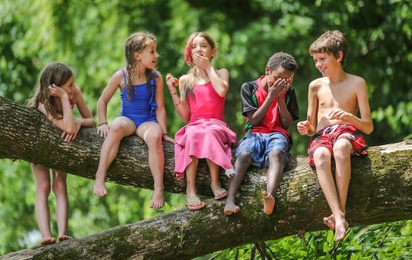 Left to right - Audrey Bell-9, Kaitlyn Bell-7, Afrika Gorman-9, Konji Gorman-7 and Jaume Gorman-12 enjoy a laugh as they sat on a tree limb on the banks of the Chattahoochee enjoying a snack during their outing on Monday, May 18, 2015. The two home school families enjoyed a warm day for a river outing on the Chattahoochee at the Paces Mill Unit of the Chattahoochee River National Recreation Area in Cobb County located two miles south of Cumberland Mall and Cobb Galleria on US Highway 41. JOHN SPINK / JSPINK@AJC.COM