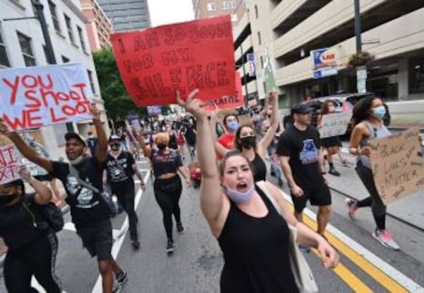 Protesters voice their opinions with signs Friday in Atlanta.