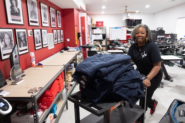 Cher’Don Reynolds, President and CEO of She Prints It, works on some embroidery orders in her basement production studio in Lithonia on Monday, Dec. 23, 2024.  (Ben Gray for the Atlanta Journal-Constitution)