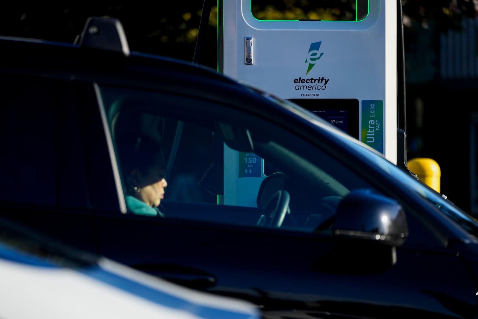 FILE - A driver waits in their car while charging their electric vehicles at an Electrify America station, Oct. 9, 2024, in Seattle. (AP Photo/Lindsey Wasson, File)