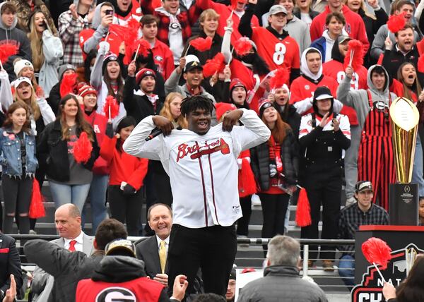 Georgia defensive lineman Jordan Davis shows his hidden Braves jersey under his shirt as he speaks on the stage during ae celebration of Georgia’s College Football Playoff national championship at Sanford Stadium in Athens on Jan. 15, 2022. (Hyosub Shin / Hyosub.Shin@ajc.com)