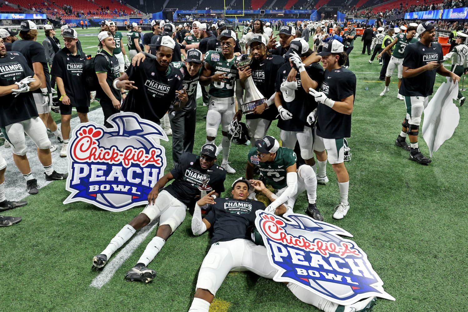 Michigan State Spartans players celebrate their 31-21 win against the Pittsburgh Panthers during the Chick-fil-A Peach Bowl at Mercedes-Benz Stadium in Atlanta, Thursday, December 30, 2021. JASON GETZ FOR THE ATLANTA JOURNAL-CONSTITUTION