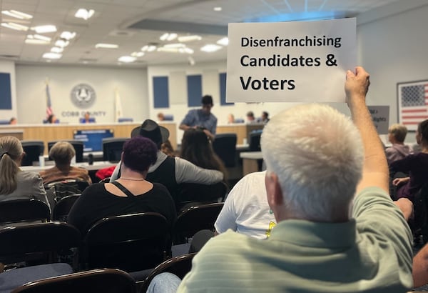 Marietta resident Donald Barth holds a sign in protest at a Cobb County Board of Elections and Registration meeting on Tuesday, March 5, 2024 in Marietta. Barth was unable to qualify to run in District 2 because of the ongoing dispute over the county's electoral map. (Taylor Croft/taylor.croft@ajc.com)