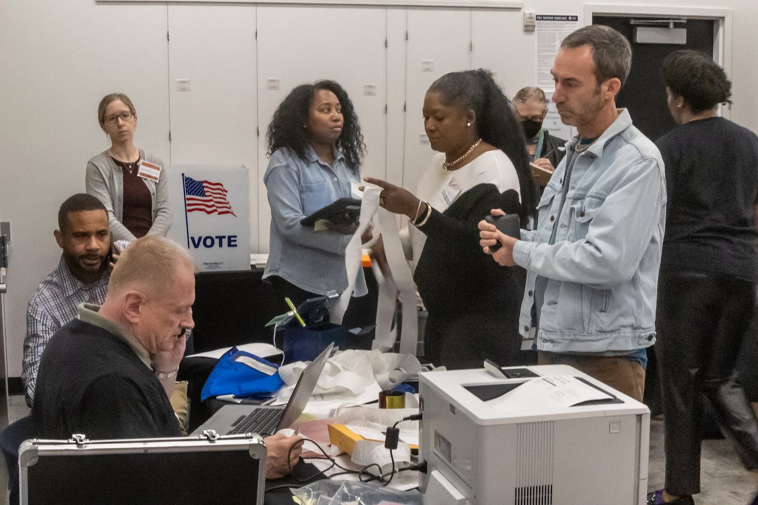 Poll manager, Dan Rauzi (left-seated) directs traffic with other poll workers at the Joan P. Garner Library located at 980 Ponce De Leon Ave N in Atlanta on Tuesday, Oct. 15, 2024. Polling places opened for the first day of early voting Tuesday as Georgia prepares for another tour as one of America’s most hotly contested states. The state’s 8.2 million registered voters will consider important races up and down the ballot. (John Spink/AJC)