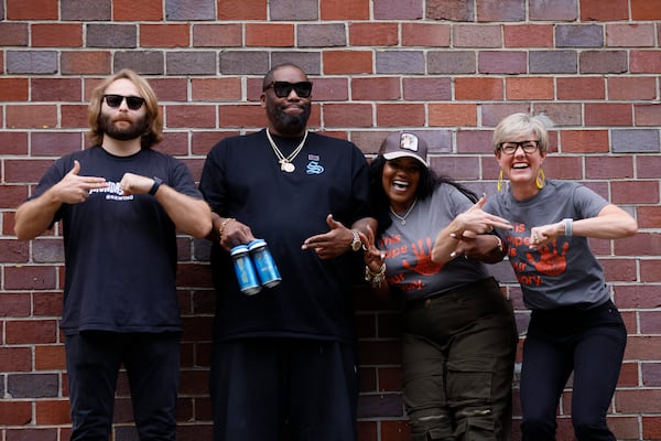 Peter Kiley (from left), brewmaster at Monday Night Brewery, rapper Killer Mike and PAWKids founder LaTonya Gates and board director Elisabeth Irwin pose Wednesday, Sept. 20, 2023, for a photograph to celebrate the partnership that will produce a beer to benefit the nonprofit organization. The hand gestures are the symbol for the rap group Run the Jewels. (Photo: Miguel Martinez / miguel.martinezjimenez@ajc.com)