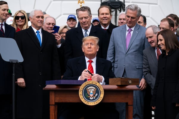 FILE - President Donald Trump signs a new North American trade agreement with Canada and Mexico, at the White House in Washington, Jan. 29, 2020. (AP Photo/ Evan Vucci, File)