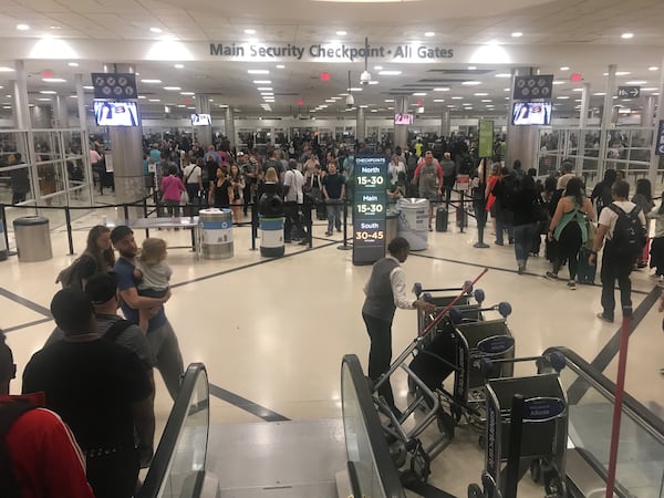 Memorial Day weekend travel is in full swing at Hartsfield-Jackson International Airport. Security lines for the main checkpoint stretched through the domestic terminal atrium and began extending into baggage claim by 7:30 a.m. Friday, May 24, 2019. (Photo: Kelly Yamanouchi/AJC)