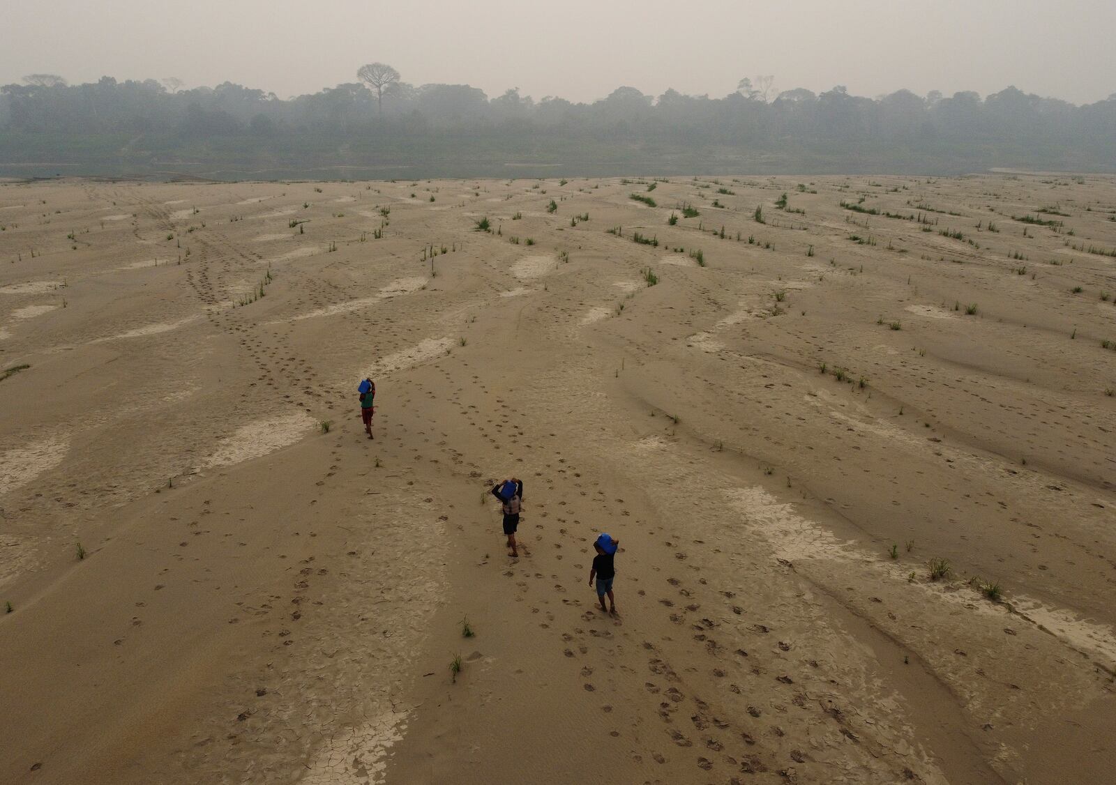 Residents transport drinking water from Humaita to the Paraizinho community, along the dry Madeira River, a tributary of the Amazon River, during dry season, Amazonas state, Brazil, Sunday, Sept. 8, 2024. (AP Photo/Edmar Barros)