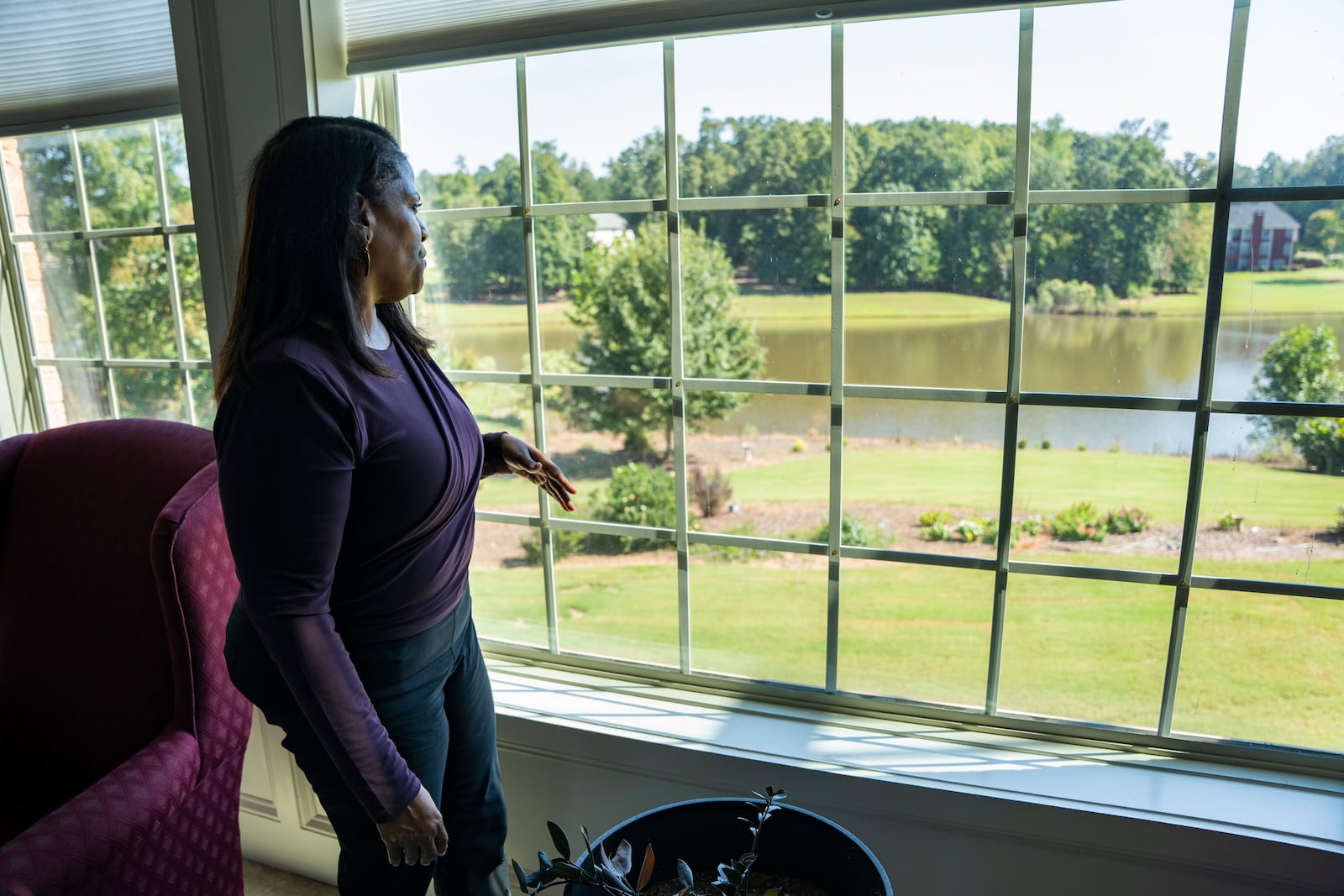 Kathy Atkins gazes out the living room window of her home Oct. 8, recalling recent days when smog filled the air and a similar "fog" of anxiety settled in. She recounts the uncertainty of not knowing if it was safe to sit outside on her porch in the aftermath of the BioLab incident in Conyers. Olivia Bowdoin for the AJC.