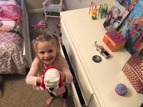 My 4-year-old daughter shows off her plush UGA mascot, which she keeps next to a Zell Miller button in her room.