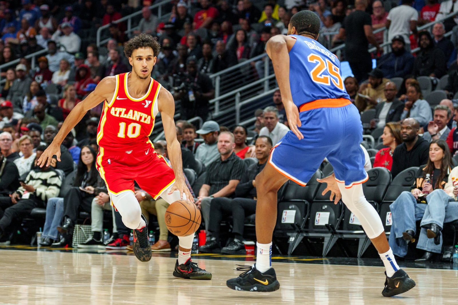 Atlanta Hawks forward Zaccharie Risacher (10) drives the lane while guarded by New York Knicks forward Mikal Bridges (25) during the first half of an NBA basketball game, Wednesday, Nov. 6, 2024, in Atlanta. (AP Photo/Jason Allen)