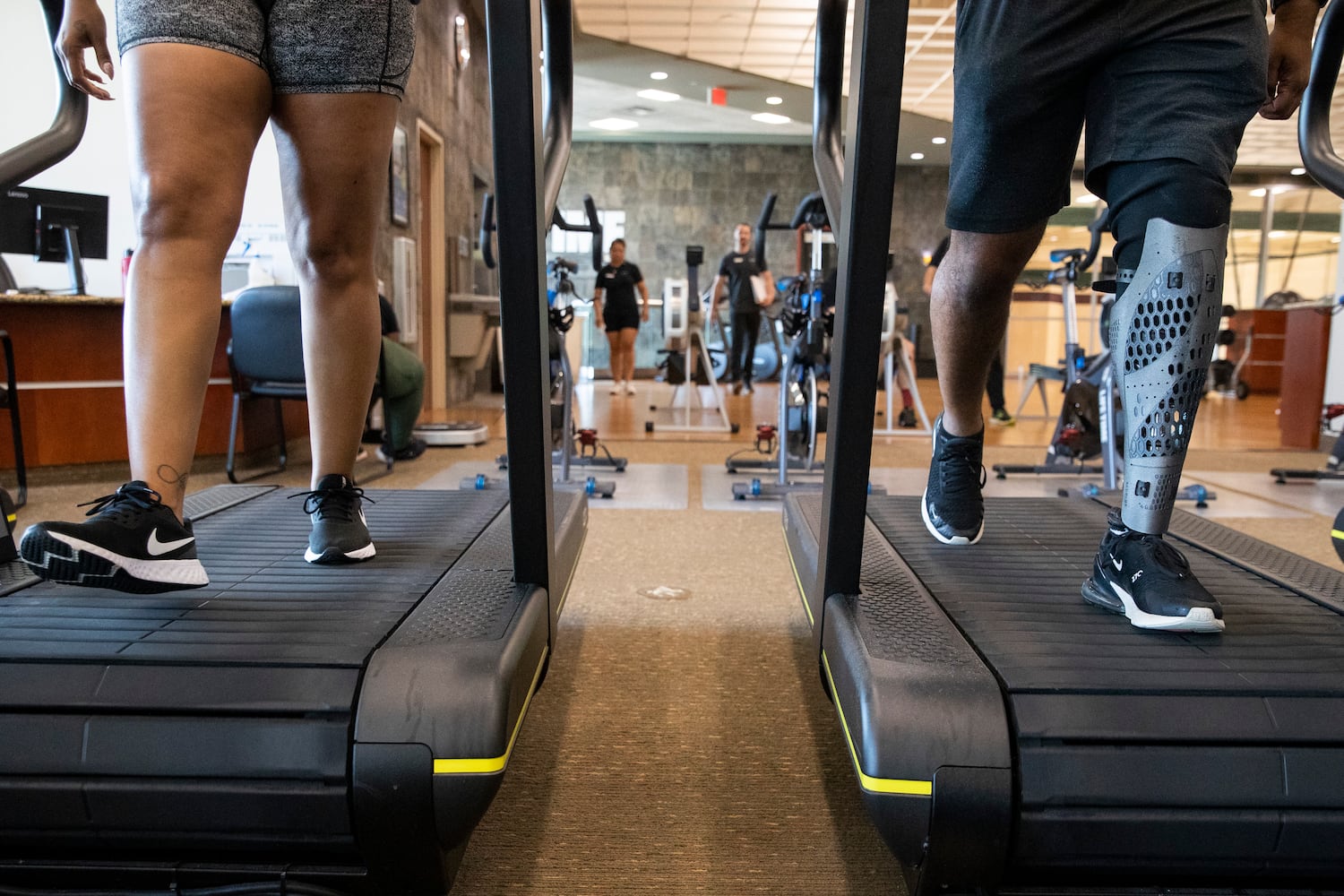 Kaye and Tiran Jackson walk on a treadmill at Life Time Woodstock on Wednesday, July 6, 2022, in Woodstock, Georgia. Tiran Jackson said fitness is important to him to ensure he can continue to walk and maintain his balance with his leg and prosthetic. (Chris Day/Christopher.Day@ajc.com)