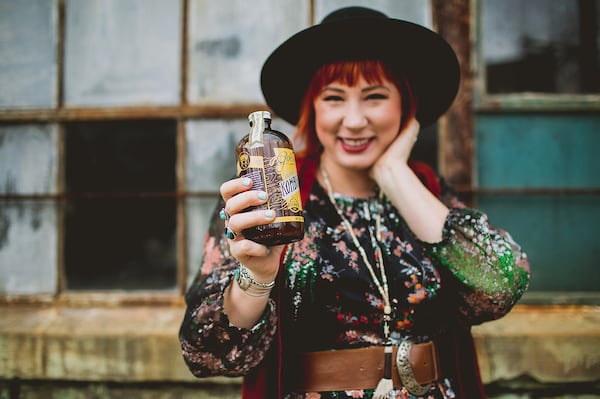 Melanie Wade holds a bottle of Golda Kombucha / Contributed by Golda Kombucha