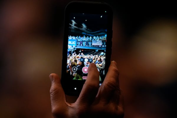 A supporter uses their phone during a Rally for our Republic gathering, Saturday, March 22, 2025, in Atlanta. (AP Photo/Mike Stewart)