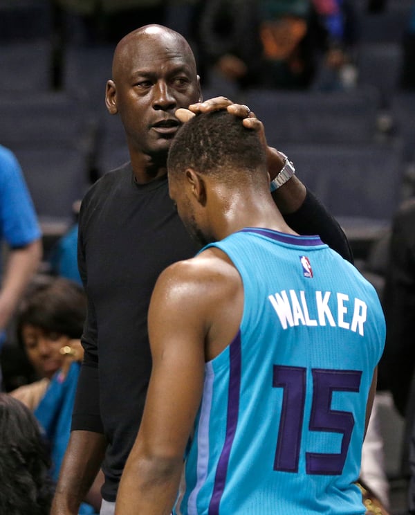 Charlotte Hornets owner Michael Jordan, left, pats Kemba Walker, right, on the head after a home loss to the Atlanta Hawks in 2015. The Hawks won 94-92. (AP Photo/Chuck Burton)