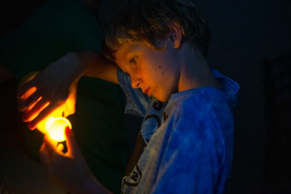 Alexanndre Limousy learns to candle an egg during a meeting of the Cobb County 4-H's Young Farmers Club. Light is used to see shapes inside an unbroken egg to evaluate its quality. CHRISTINA MATACOTTA FOR THE ATLANTA JOURNAL-CONSTITUTION. 
