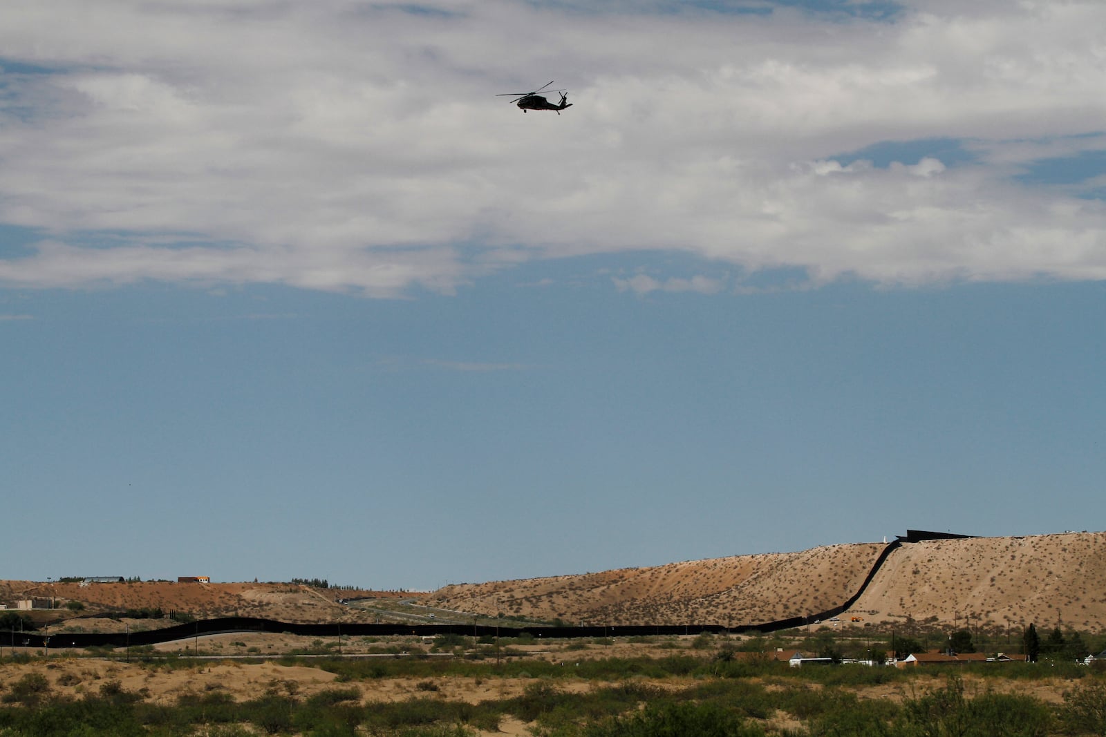 A surveillance helicopter traces a line in the sky above the Southwest border with Mexico at Sunland Park, N.M., Thursday, Aug. 22, 2024. (AP Photo/Morgan Lee, File)